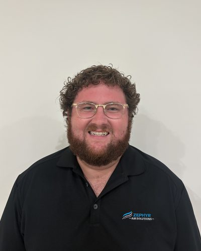 Jackson Carter, co-founder of Zephyr Air Solutions, smiling in a black Zephyr Air Solutions polo shirt
