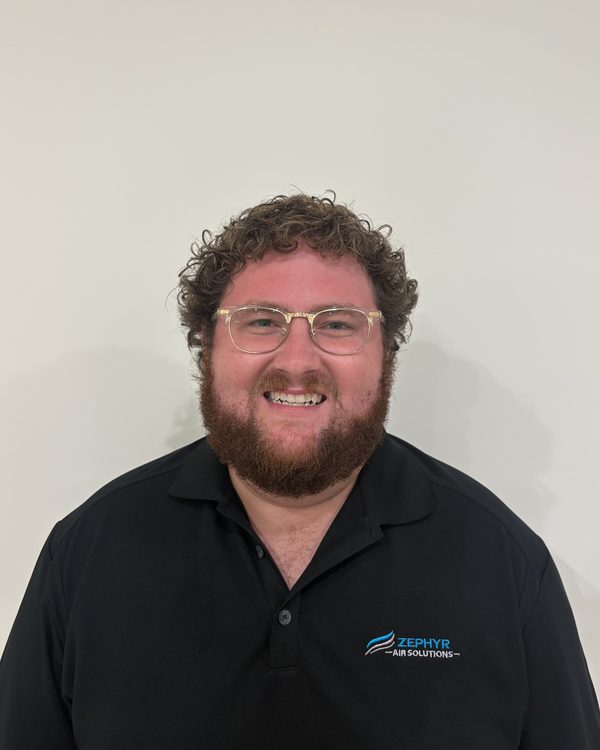 Jackson Carter, co-founder of Zephyr Air Solutions, smiling in a black Zephyr Air Solutions polo shirt